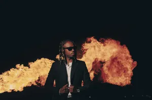 Manin Black Suitwith Fire Background Wallpaper