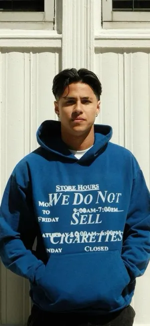 Manin Blue Hoodie Standing Against White Door Wallpaper