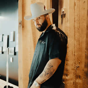 Manin White Hat Leaning Against Wooden Wall Wallpaper