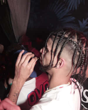 Manwith Braided Hairstyleat Party Wallpaper