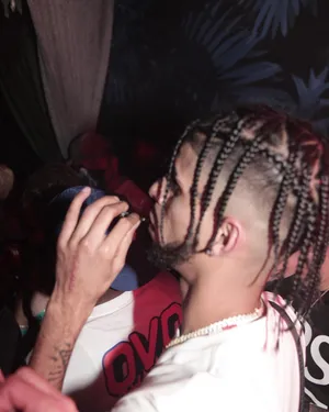 Manwith Braided Hairstyleat Party Wallpaper