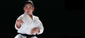 Martial Artists In Action Wearing Various Uniforms Wallpaper