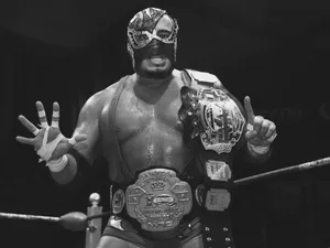 Masked Wrestlerwith Championship Belts Wallpaper