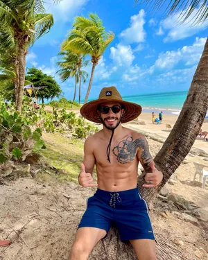 Matheus Nicolau Sitting Beside A Palm Tree Wallpaper