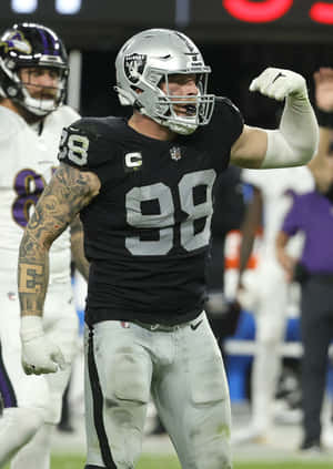 Maxx Crosby Flexing Against Baltimore Ravens Wallpaper
