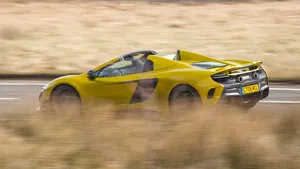 Mclaren 675lt Spider Cruising Down The Road Wallpaper