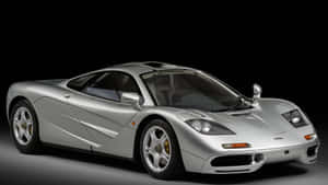 Mclaren F1 Sports Car On A Scenic Road Wallpaper