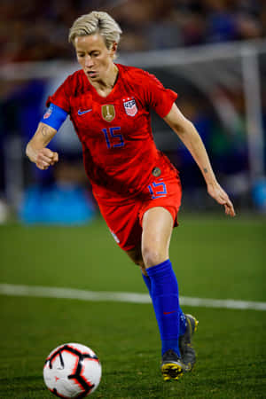 Megan Rapinoe In Action On The Football Field Wallpaper