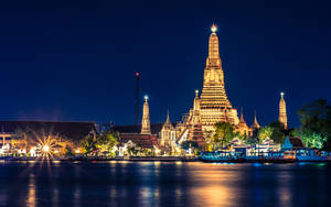 Mesmerizing Night View Of Wat Arun In Bangkok Wallpaper