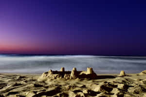 Mesmerizing Sandcastle On A Serene Beach Wallpaper