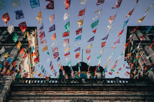 Mexican Fiesta Flags Over Colonial Architecture Wallpaper