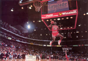 Michael Jordan Soars Above The Rim With A Gravity-defying Dunk. Wallpaper