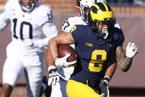 Michigan Football Player Running With Ball Wallpaper