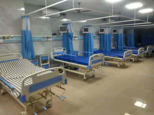 Modern Hospital Room Featuring A Fully Equipped Hospital Bed Wallpaper