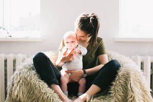 Mom And Son Sitting On Couch Wallpaper