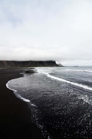 Moody_ Black_ Sand_ Beach_ Cliffs Wallpaper