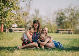 Mother And Her Three Daughters Representing A Tangible Family Love Wallpaper