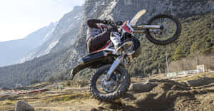 Motocross Bike Mid Air Stunt Mountain Backdrop Wallpaper