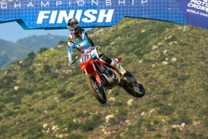 Motocross Racer Jumpsto Finish Line Wallpaper