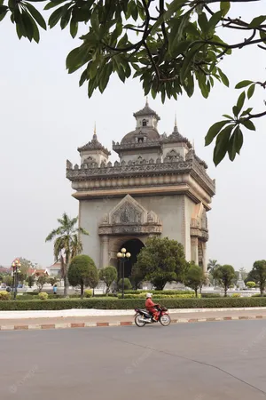 Motorcycle Passing By Patuxai Monument Wallpaper