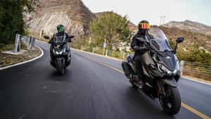 Motorcyclists_ Speeding_on_ Mountain_ Road Wallpaper