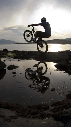 Mountain Biker Silhouetteat Sunset Wallpaper