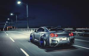 Moving Silver Nissan Gtr Along The Road Wallpaper