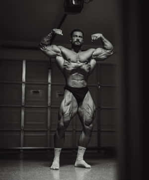 Muscular Man Posingwith Dumbbell Wallpaper