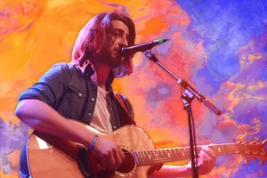 Musician Performing Live Against Colorful Backdrop Wallpaper