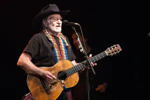 Musician Willie Nelson With Guitar Wallpaper