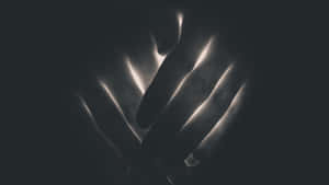 Mysterious Dark Hand Emerging From The Shadows Wallpaper