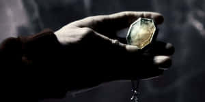 Mysterious_ Hand_ Holding_ Magical_ Locket Wallpaper