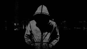 Mysterious Hooded Figureat Night Wallpaper