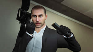 Mysterious Manin Suitwith Guns Wallpaper