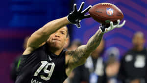 N F L Player Catching Football During Combine Wallpaper