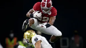 Najee Harris Athletic Hurdle Over Defender Wallpaper