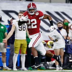 Najee Harris In Action Running With Football Wallpaper