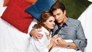 Nathan Fillion Hugging Colorful Pillows Wallpaper