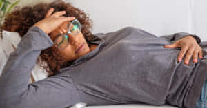 Nauseous Woman In Gray Sweater Wallpaper