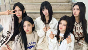 New Jeans Group Photo Staircase Sitting Wallpaper