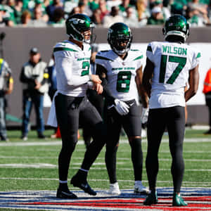 New York Jets Players Discussion On Field Wallpaper