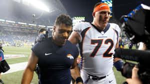 Nfl Stars In Action - Russell Wilson And Garett Bolles Wallpaper