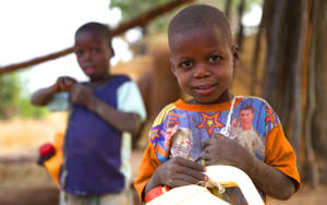 Nigerian Boys Collecting Water In Plastic Containers Wallpaper