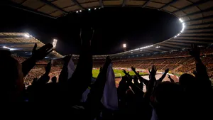 Nighttime Soccer Stadium Cheering Fans Wallpaper