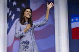 Nikki Haley Raising Her Hand In Determined Gesture Wallpaper