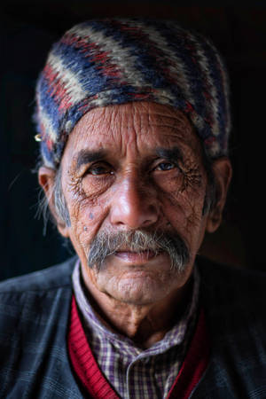 Old Man In Colorful Stripes Cap Wallpaper