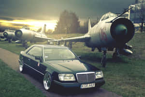 Old Mercedes Benz Parked Beside An Airplane Wallpaper