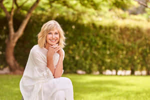 Olivia Newton-john Posing In A Stylish Outfit Wallpaper