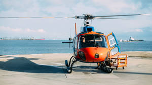 Orange Helicopter Near Sea Wallpaper