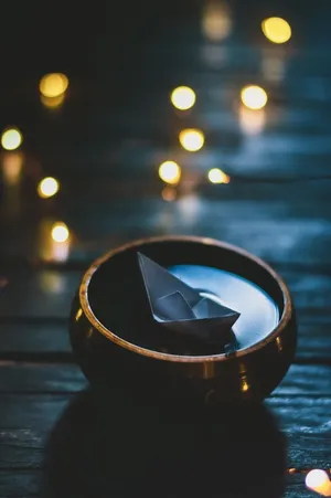 Origami Boat Floating In Bowl Wallpaper